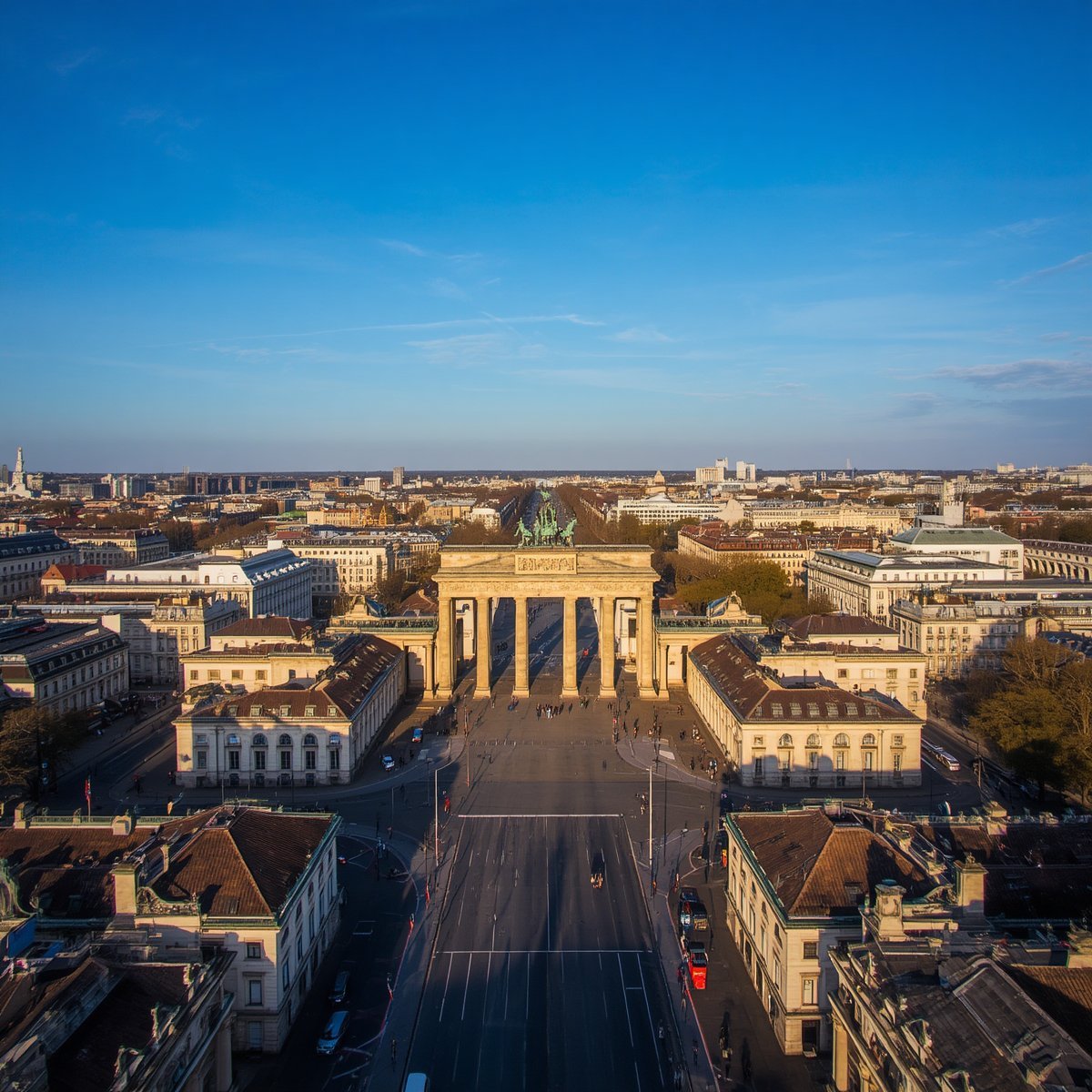 Luftaufnahme des Brandenburger Tors in Berlin mit Berliner Stadtlandschaft und klarem blauem Himmel